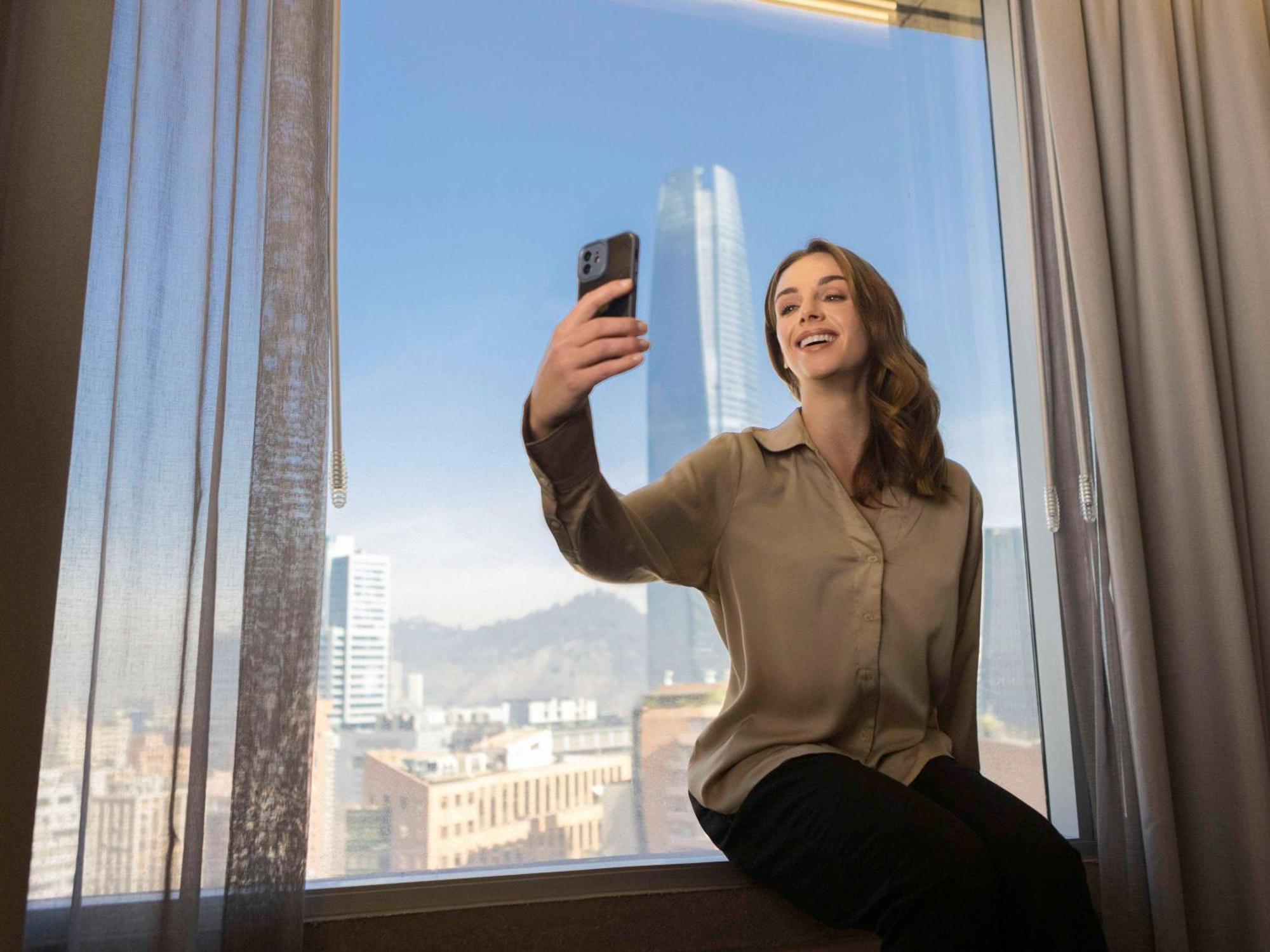 Pullman Santiago El Bosque Hotell Exteriör bild A woman taking a selfie