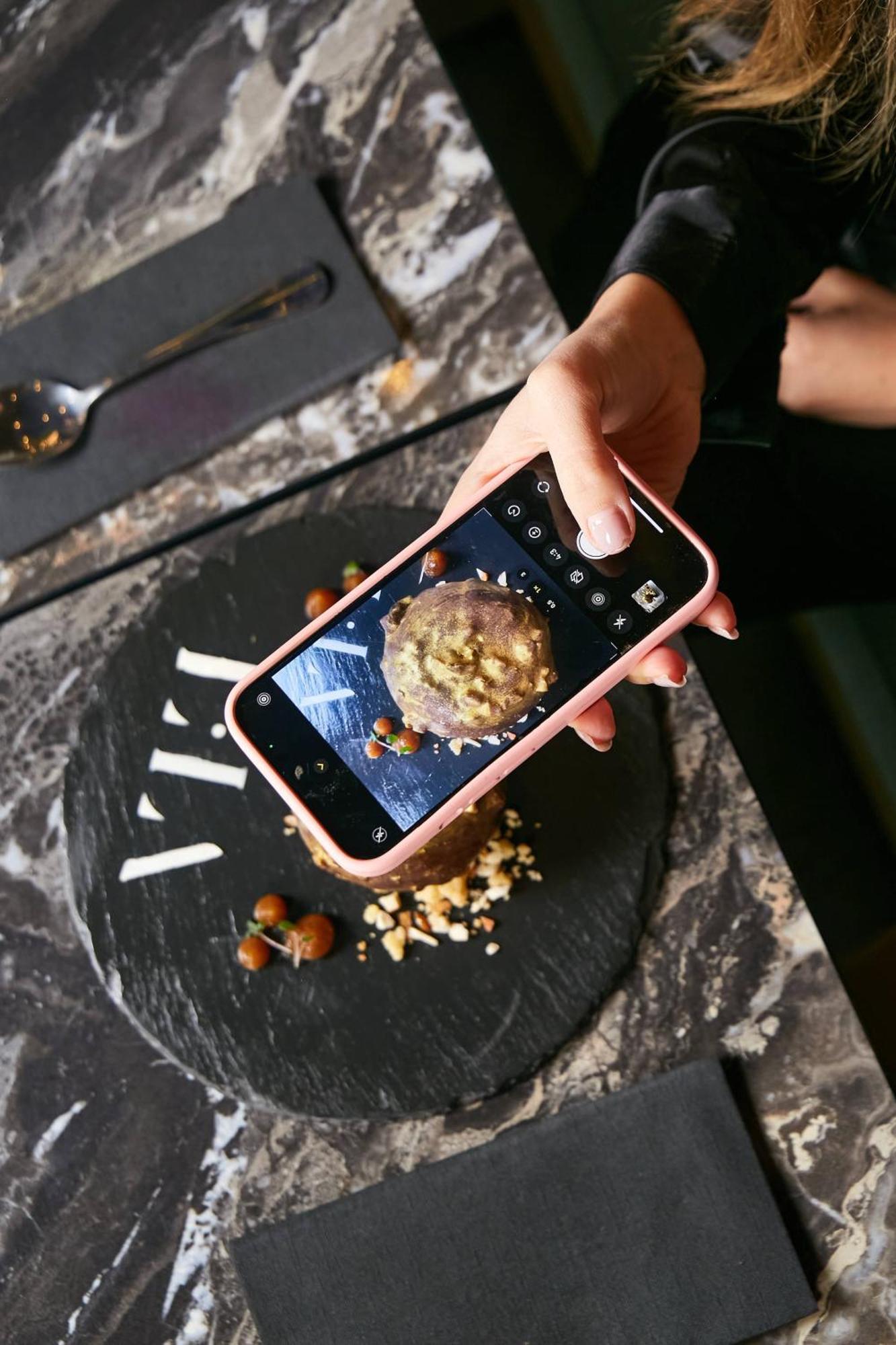 Pullman Santiago El Bosque Hotell Exteriör bild A smartphone being used to take a photograph of a food item